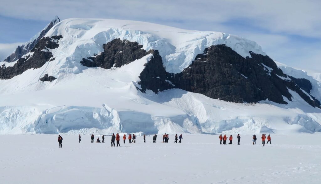 a group of people standing on top of a snow covered mountain